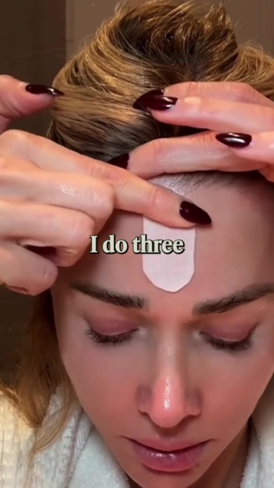 Woman applying face patches.