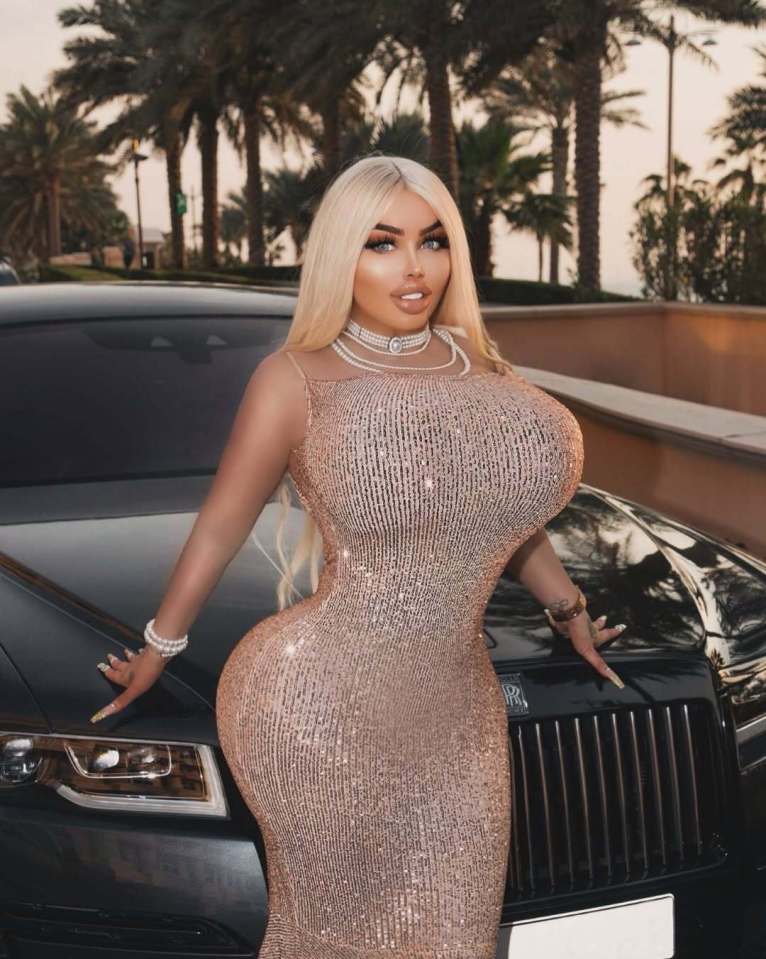 Woman in a sparkly dress posing next to a luxury car.