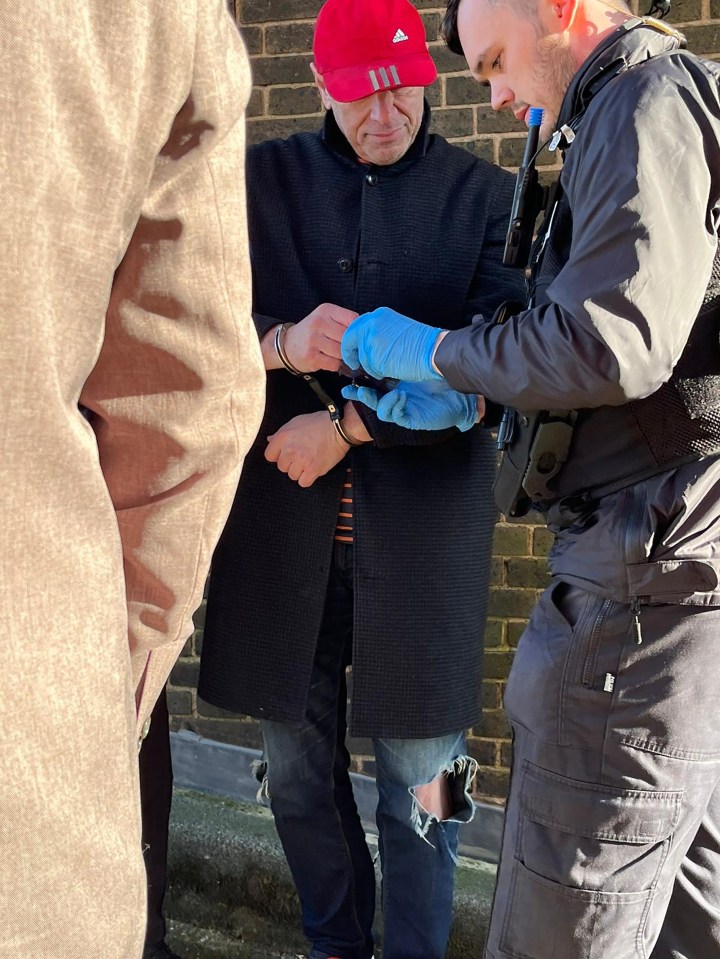 A man in handcuffs being arrested by police.