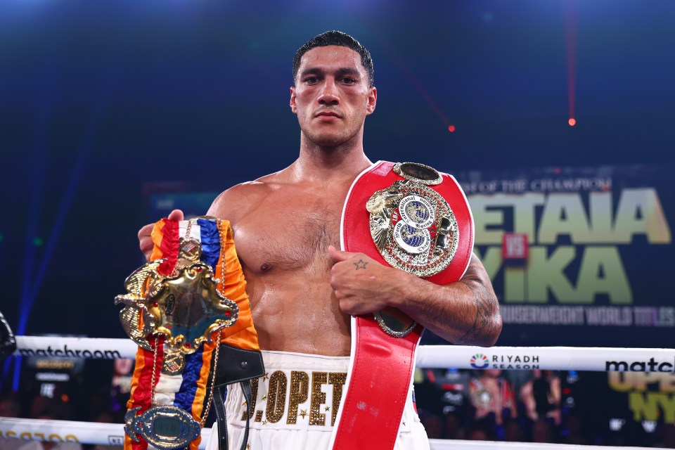 Jai Opetaia holding championship boxing belts after a win.