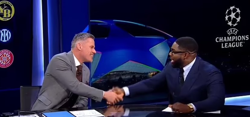 Jamie Carragher and another man shaking hands on a TV show.