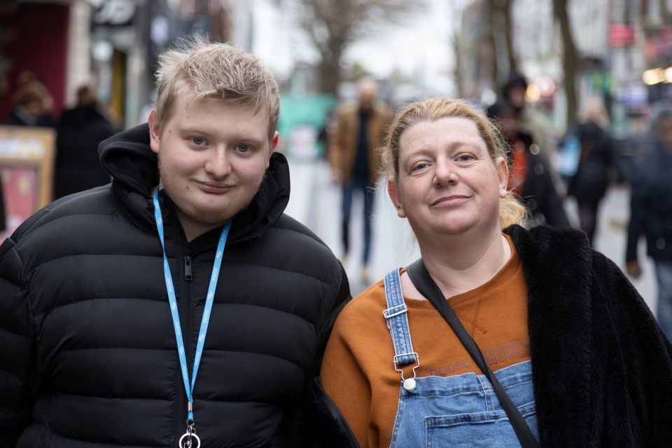 A mother and son stand together outdoors.