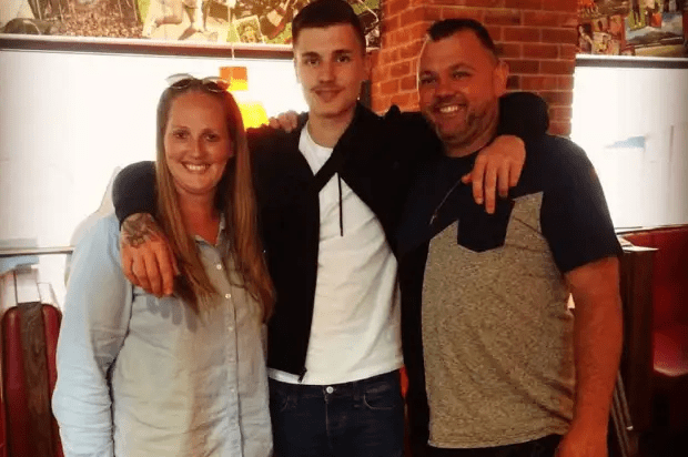 Photo of a young man with his mother and father.