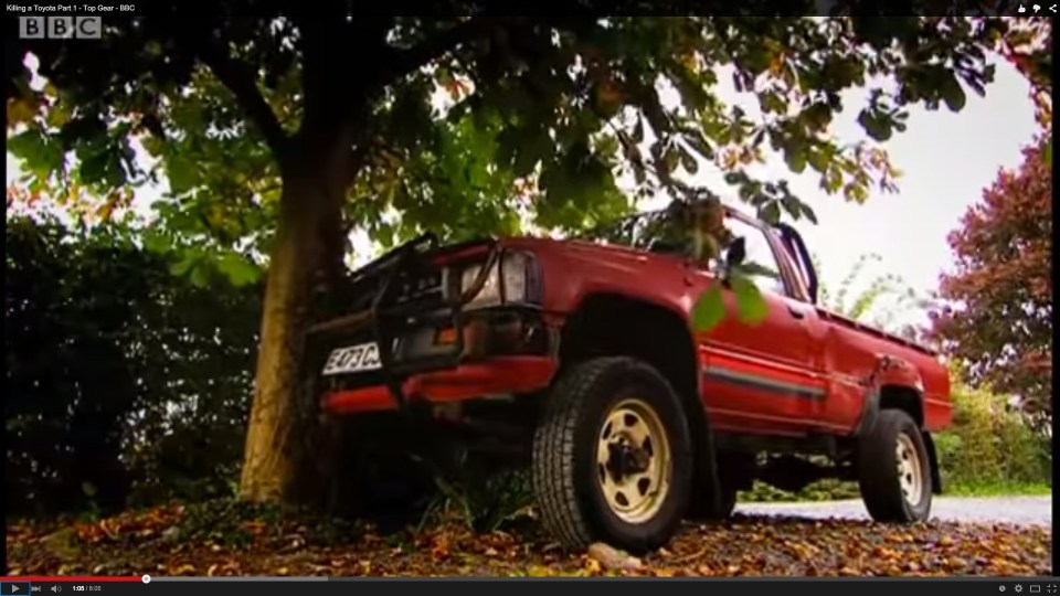 Red Toyota Hilux truck crashed into a tree.