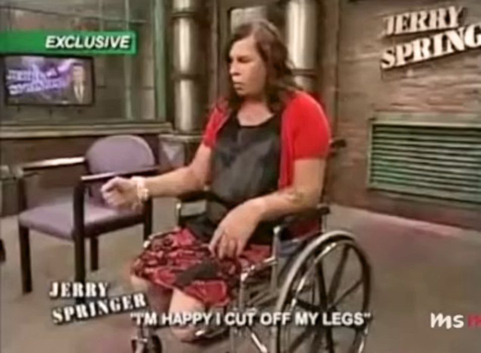 A woman in a wheelchair on the Jerry Springer show states, "I'm happy I cut off my legs."