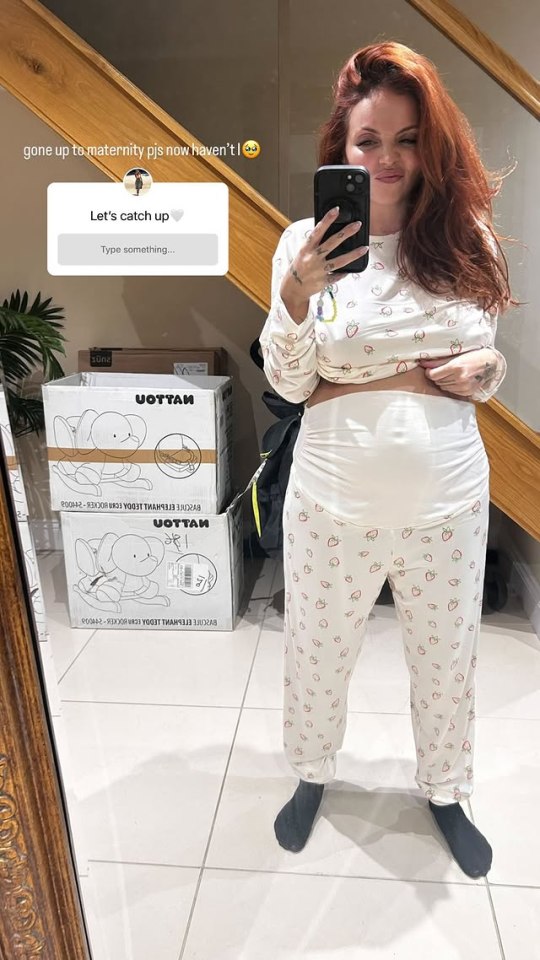 Pregnant woman in strawberry pajamas taking a selfie.