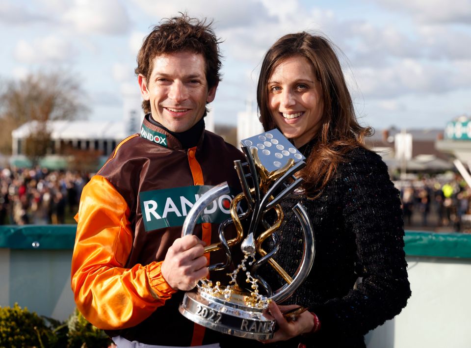 Jockey Sam Waley-Cohen and his wife Bella holding a trophy.