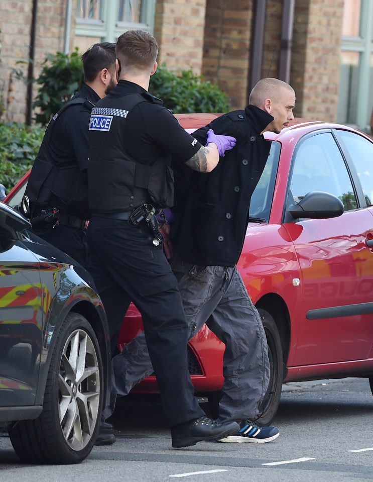 Police arresting a suspect at a murder scene.