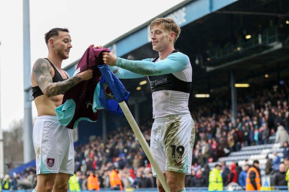 Two Burnley soccer players hold a corner flag after a match.