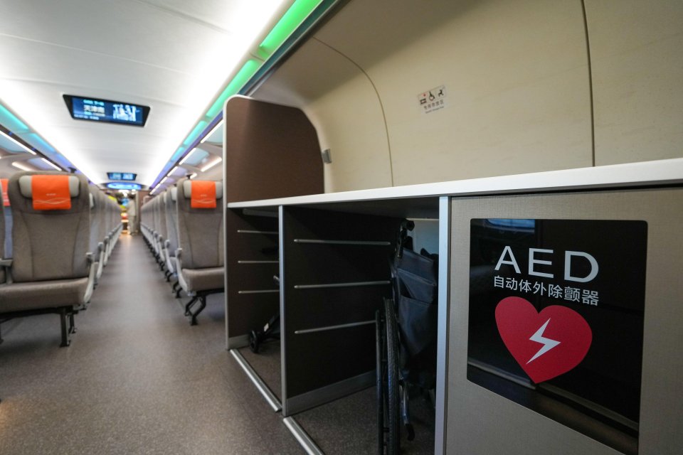 Interior of a CR450AF bullet train carriage showing an AED and a wheelchair.