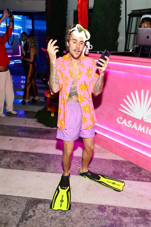 Justin Bieber at a Casamigos party wearing a pink shirt, purple shorts, and scuba gear.