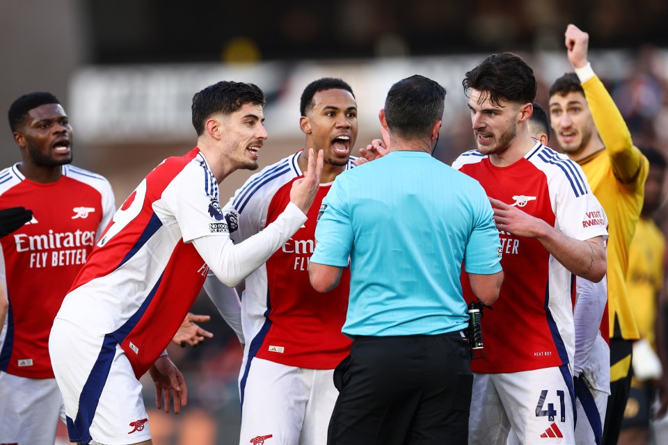 Arsenal players protesting a referee's decision.