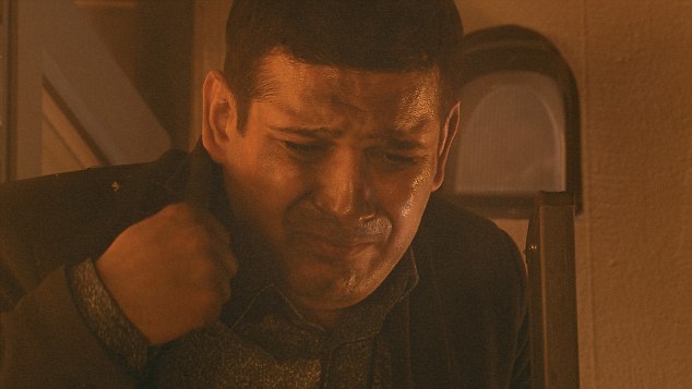 A man crying in a smoky room.