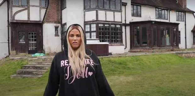 Katie Price in front of her run-down Mucky Mansion.