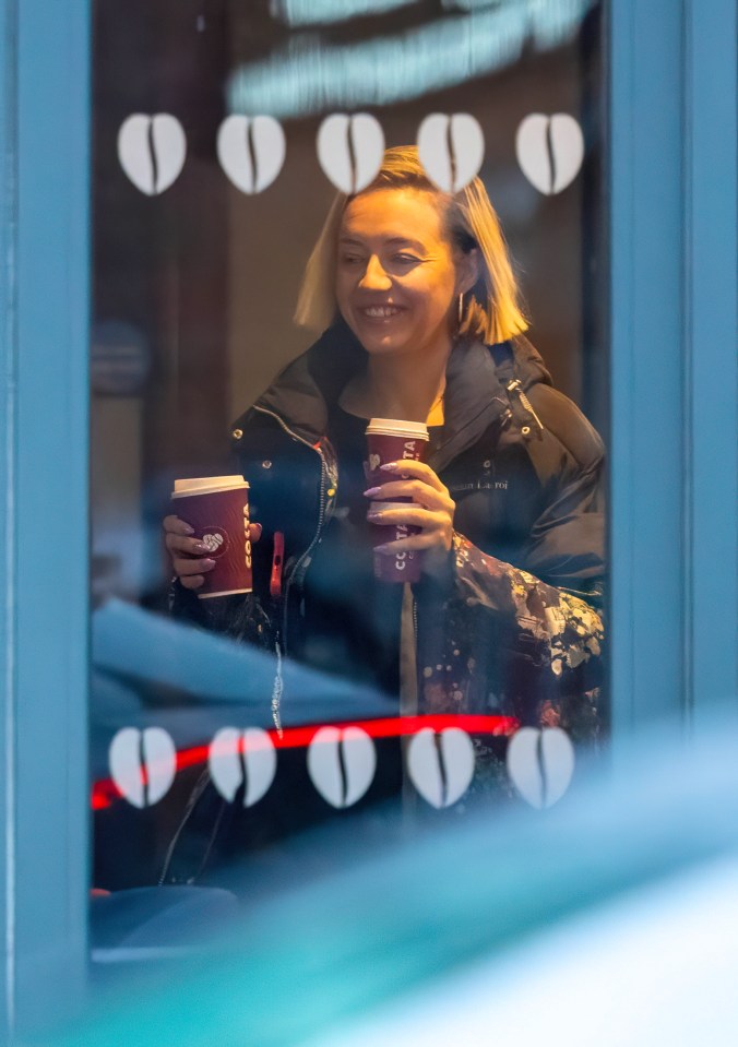 Kelsey Parker holding two coffee cups.