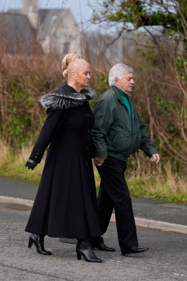 Kim Woodburn and a man walking hand-in-hand.