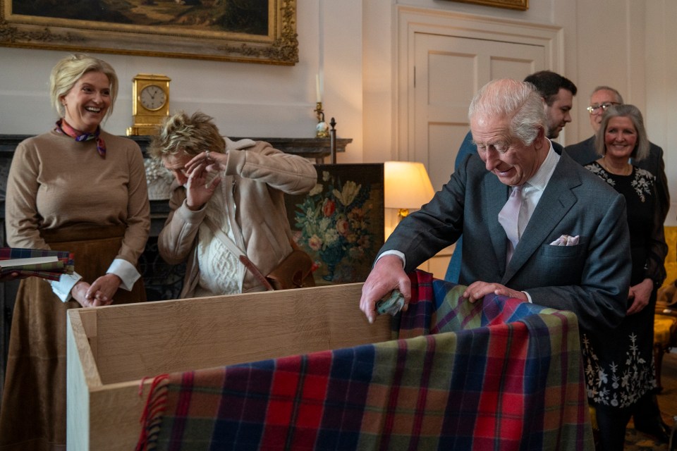 King Charles III placing garden secateurs in a time capsule.