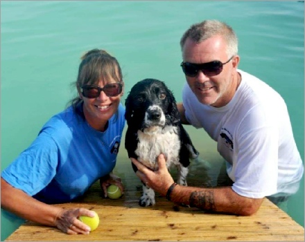 Couple and their dog in the water.