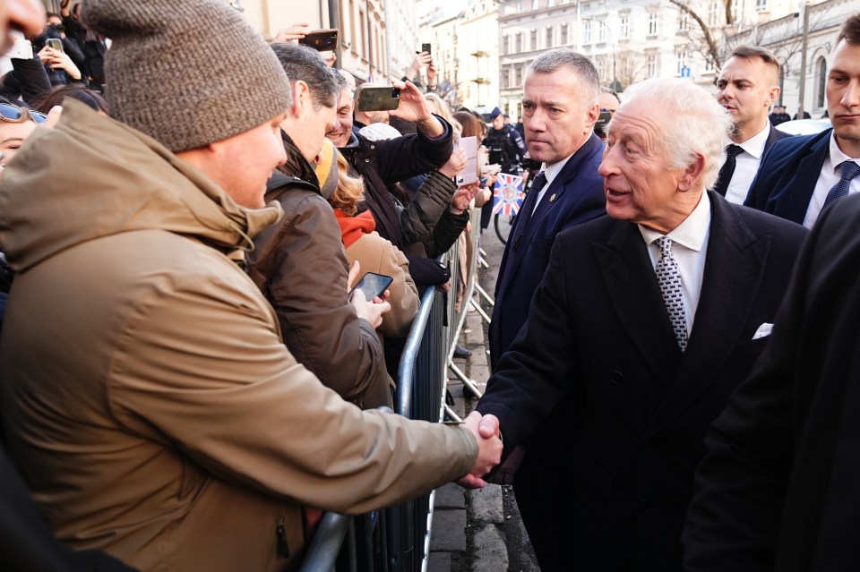 King Charles III shaking hands with a member of the public at the Jewish Community Centre in Krakow.