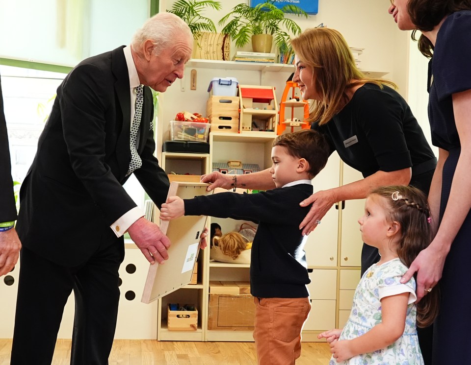 King Charles III receives a painting from children at a Jewish Community Centre in Krakow.