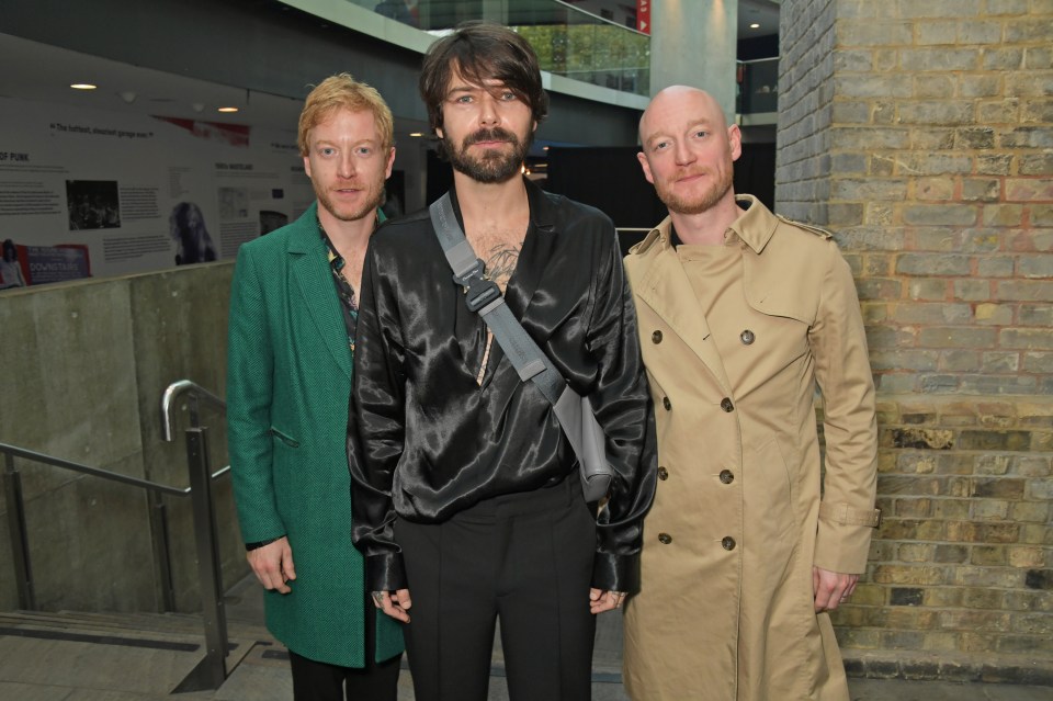 Three men from the band Biffy Clyro at an awards ceremony.