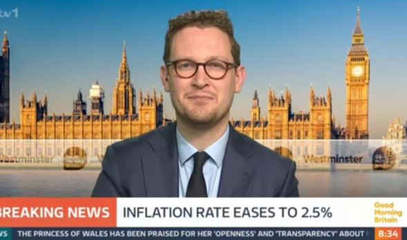 A Labour MP being interviewed in front of the Houses of Parliament; the inflation rate easing to 2.5% is shown on a news ticker.