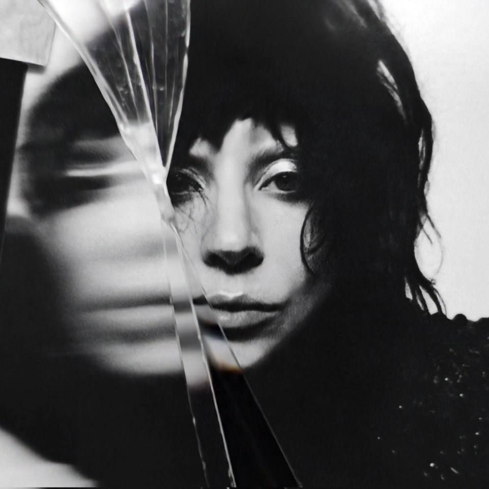 Black and white photo of Lady Gaga, partially obscured by shards of glass.