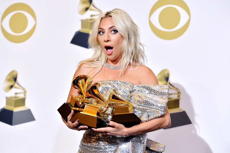 Lady Gaga holding Grammy Awards.