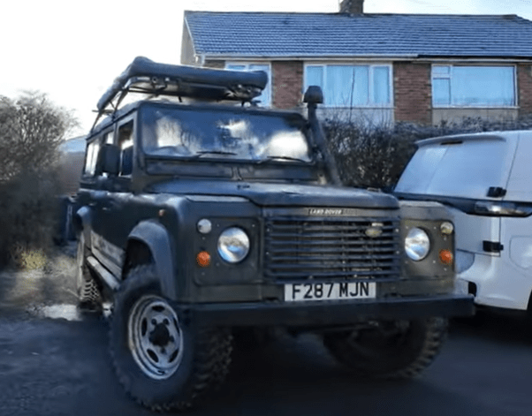 Land Rover Defender parked in front of a house.