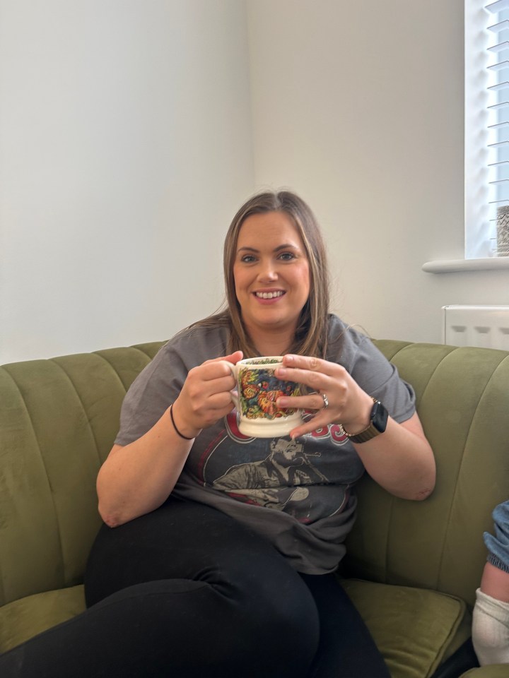 Woman sitting on a couch holding a mug.