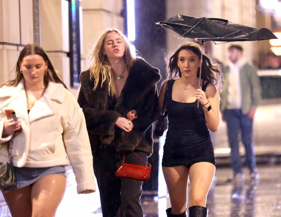 A young woman holds up a broken umbrella