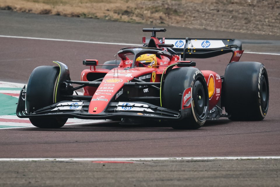 Lewis Hamilton driving a Ferrari Formula 1 car on a racetrack.