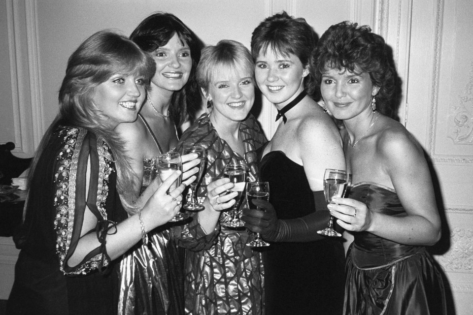 Black and white photo of the Nolan sisters toasting with champagne.