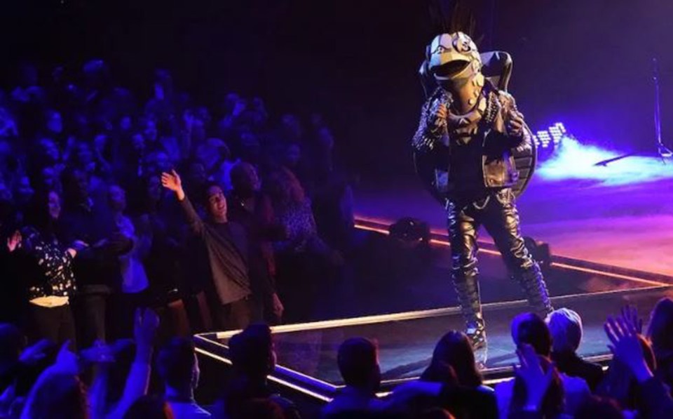 The Turtle from The Masked Singer performing live to a large audience.