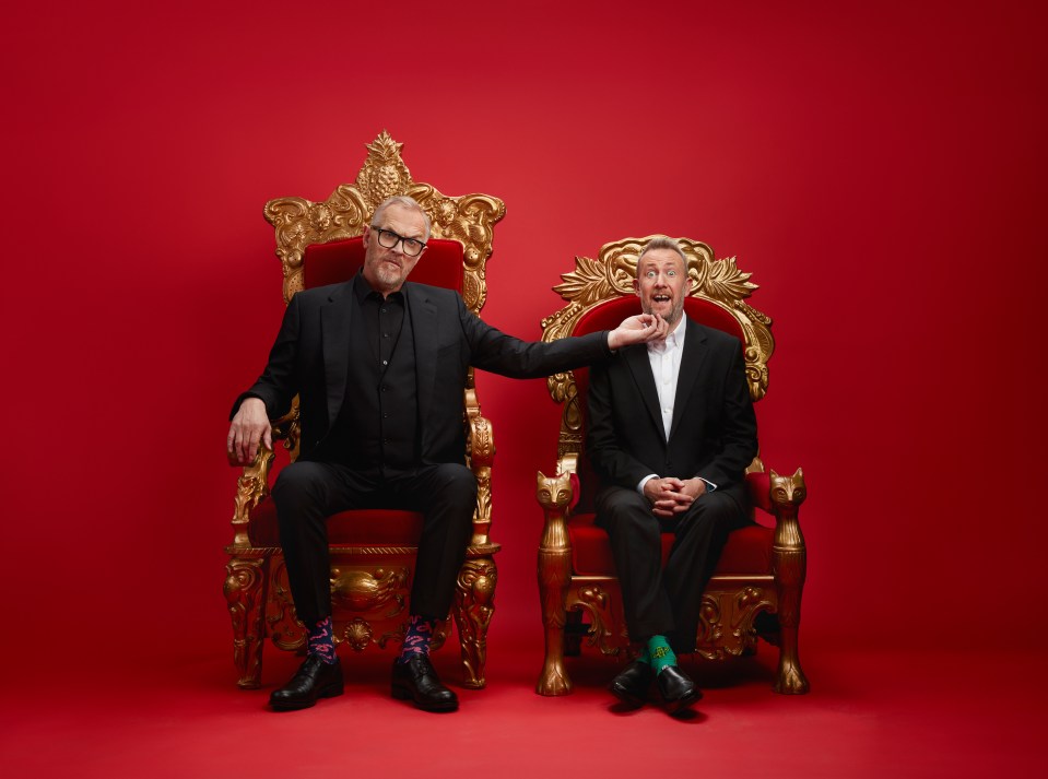 Two men in suits sitting on ornate gold thrones against a red background.  One man is playfully choking the other.