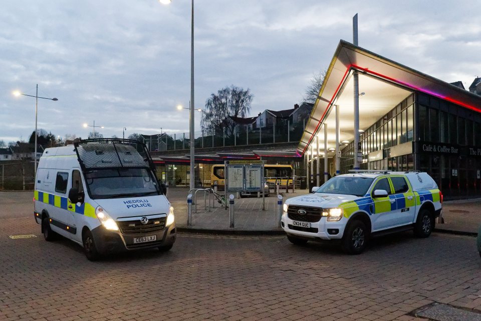 Two police vehicles parked outside a bus station.