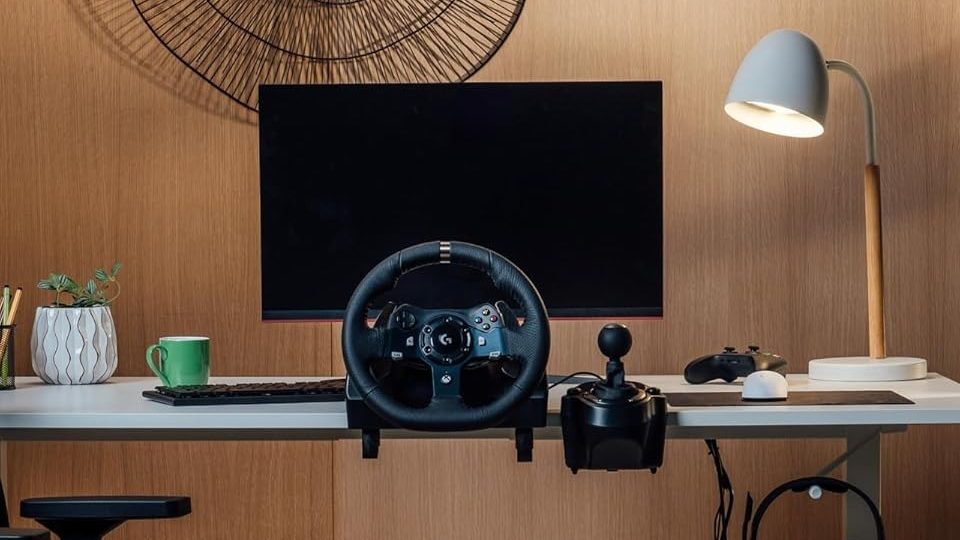 Logitech G923 racing wheel and pedals on a desk.