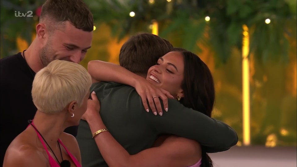 Love Island contestants embracing.