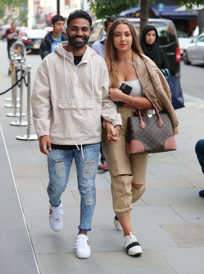 Nas Majeed and Eva Zapico holding hands while shopping.