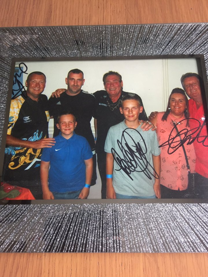 Framed photo of a group of people, including children, with autographs.