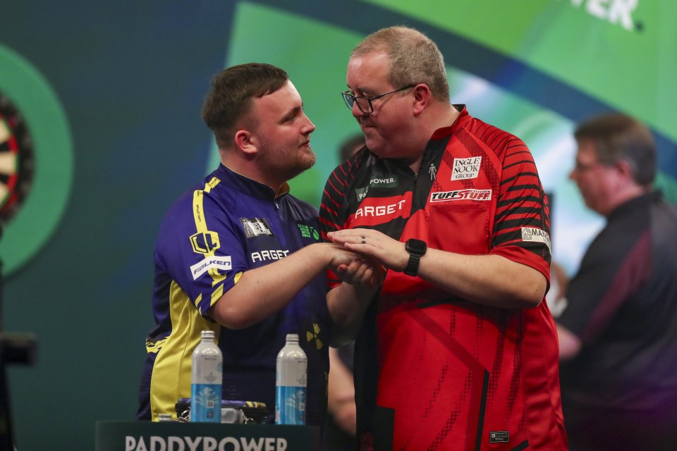 Luke Littler and Stephen Bunting shake hands after a darts match.