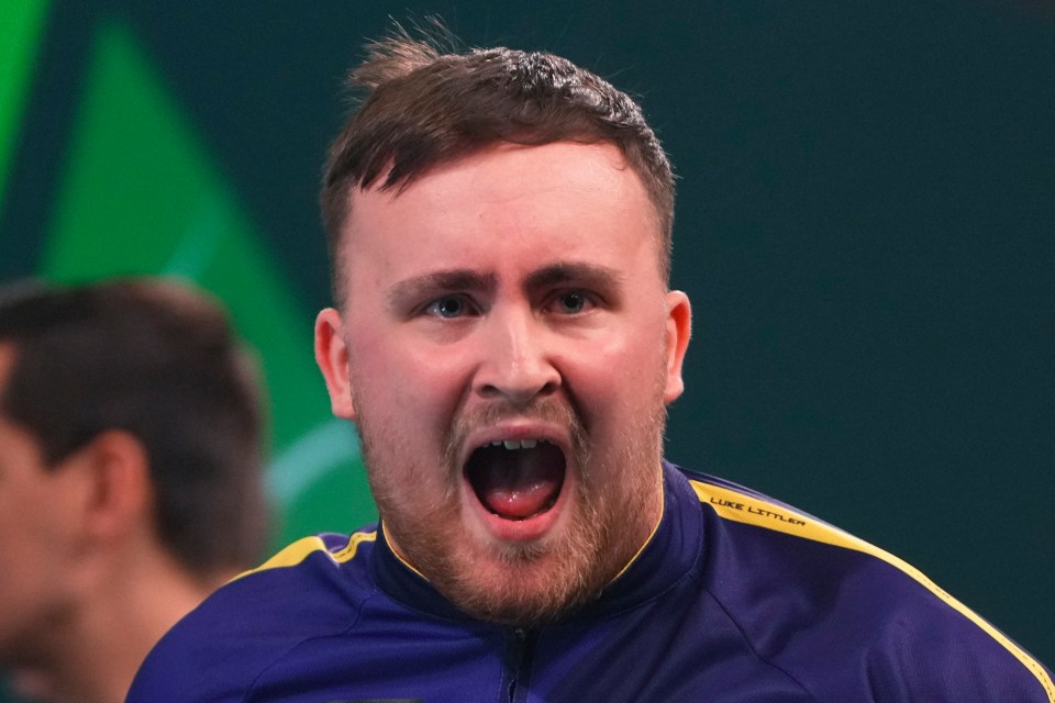 Luke Littler reacting during a darts match.