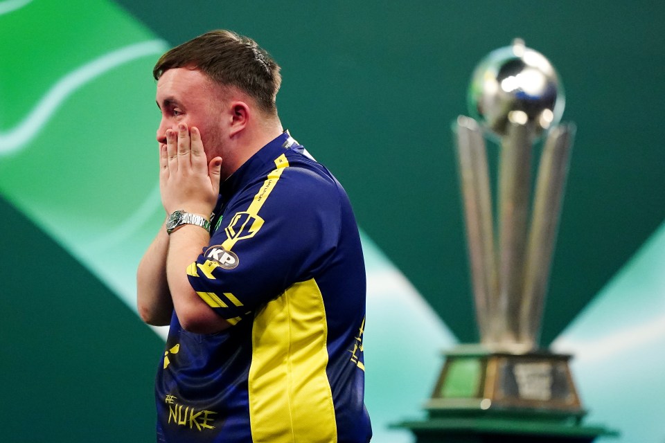 Luke Littler reacts after winning a darts championship.