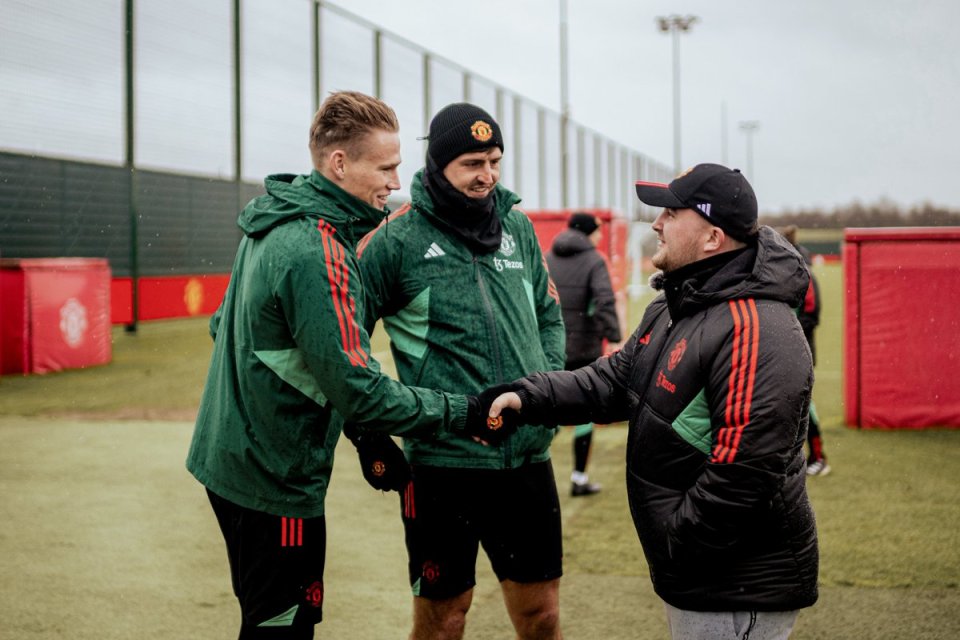 Luke Littler shaking hands with Manchester United players at Carrington training ground.