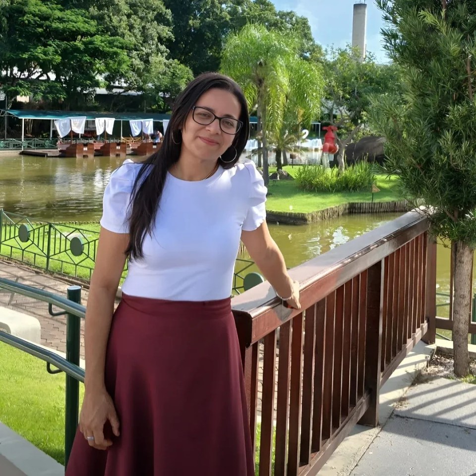 Woman in white shirt and maroon skirt at a park.