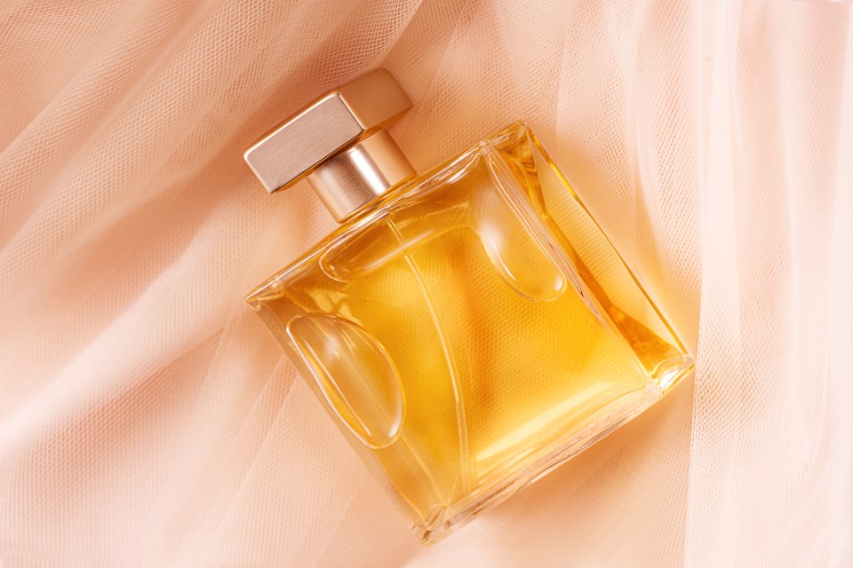 Perfume bottle on peach tulle fabric.