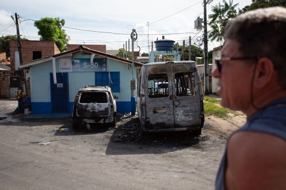 Burnt-out vehicles near a building in Manaus, Brazil.