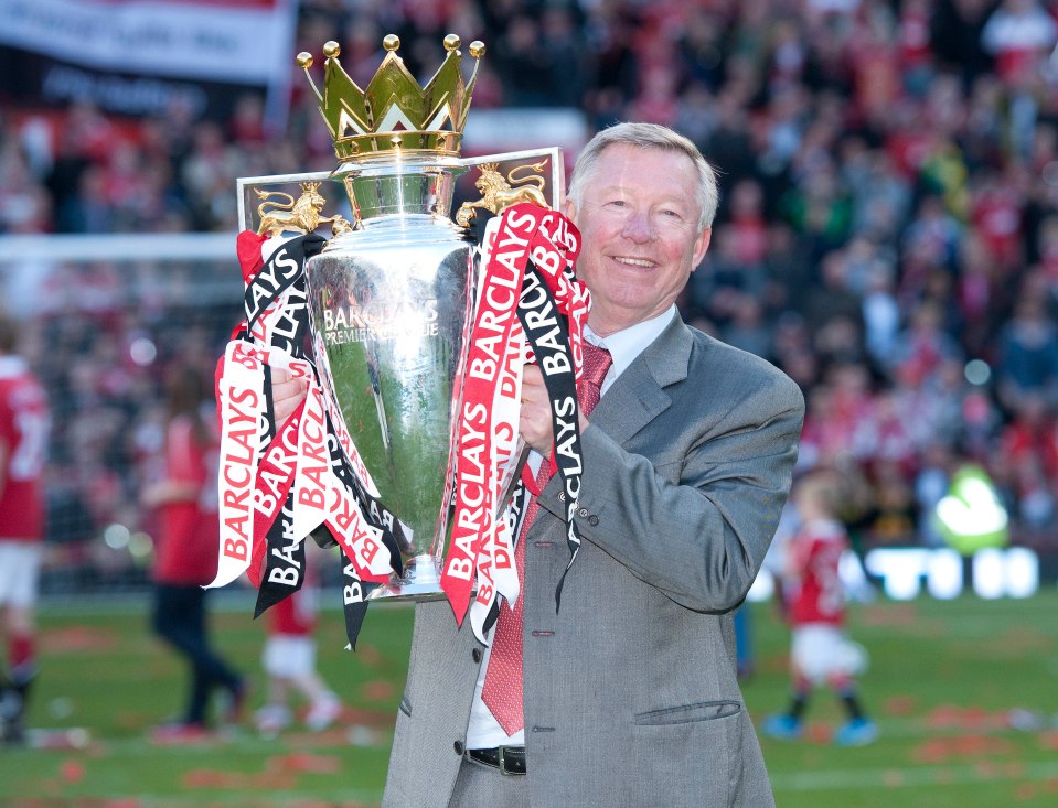 Alex Ferguson holding the Barclays Premier League trophy.