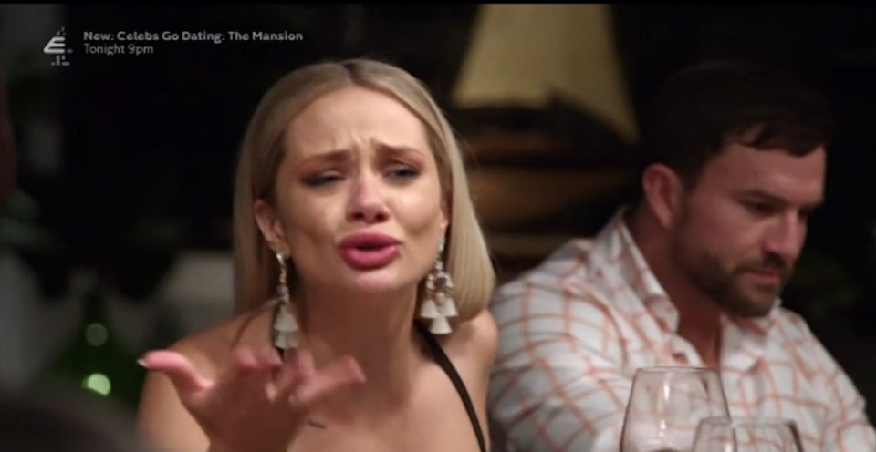 A woman emotionally confronts a man at a dinner table.