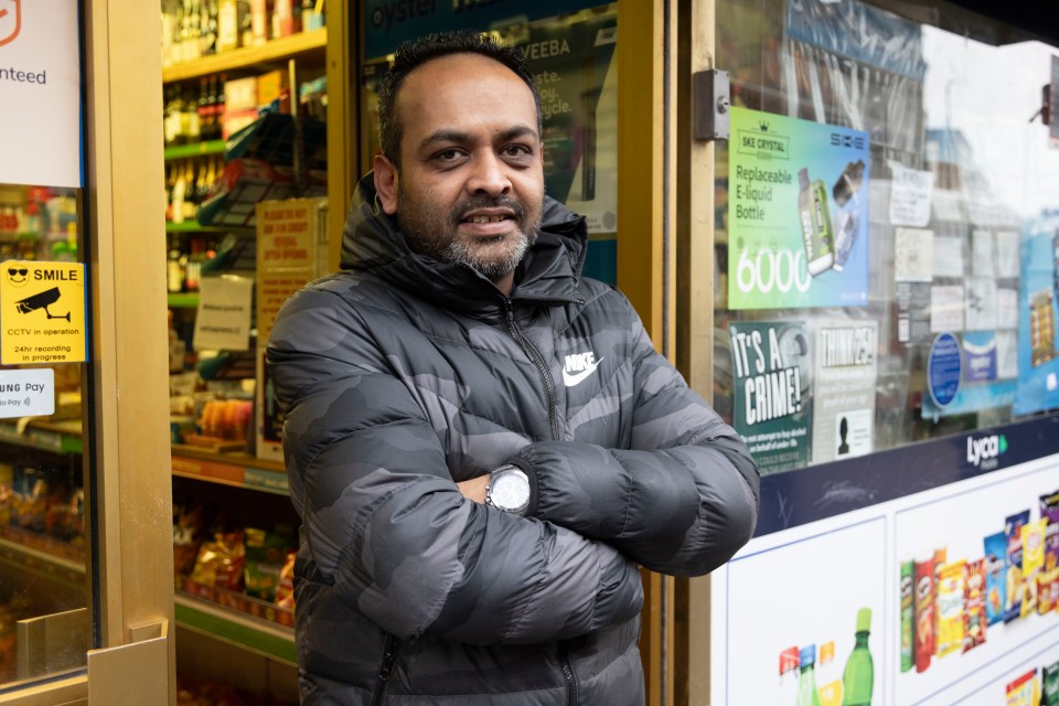 Mature Patel standing outside a shop.